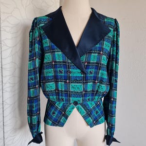 May include: A blue and green plaid blazer with a black satin collar and a double-breasted closure.