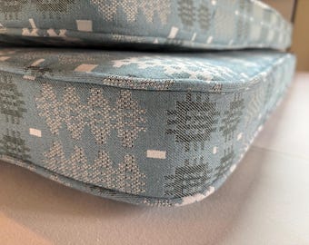 May include: Close-up of a blue and white patterned cushion with a white seam around the edge.