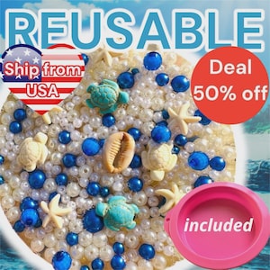 May include: A decorative arrangement featuring white and blue beads, sea turtles, starfish, and a seashell. The word "REUSABLE" is at the top. A pink bowl is included. The image has a beach theme.