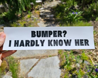 May include: White bumper sticker with black text that reads "BUMPER? I HARDLY KNOW HER"