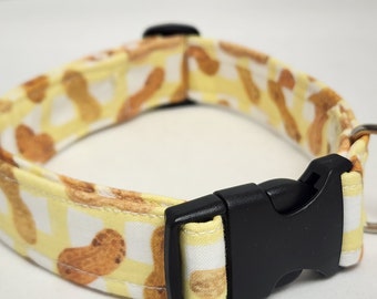 May include: A yellow and brown dog collar with a peanut pattern and a black plastic buckle.