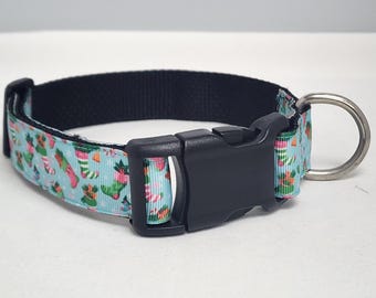 May include: A blue dog collar with a Christmas stocking pattern. The collar has a black buckle and a silver D-ring.