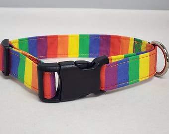 May include: A rainbow striped dog collar with a black plastic buckle. The collar is made of fabric and has a bright, colorful design.