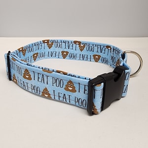 Puede incluir: Un collar para perro azul claro con una hebilla negra y un anillo plateado. El collar tiene un patrón repetido de emojis de caca marrones y el texto "I eat poo".