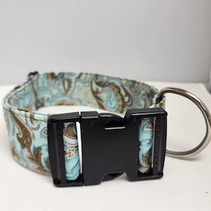 May include: A blue and brown paisley patterned dog collar with a black plastic buckle and a silver D-ring.