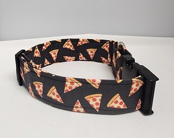 May include: A black dog collar with a repeating pattern of pizza slices. The collar has a black plastic buckle.