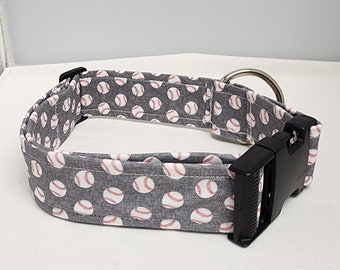 May include: A gray dog collar with a white baseball pattern. The collar has a black buckle and a silver D-ring.
