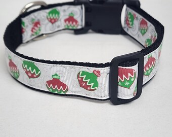 May include: White dog collar with a black buckle and a red and green Christmas ornament pattern.
