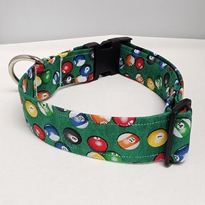 May include: A green dog collar with a black buckle and a pattern of colorful billiard balls with numbers.