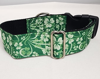 May include: A green dog collar with a shamrock pattern and a black buckle. The collar is made of a sturdy material and has a silver D-ring.