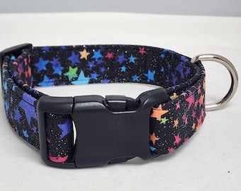 May include: A black dog collar with a colorful star pattern and a black plastic buckle. The collar has a silver metal D-ring.