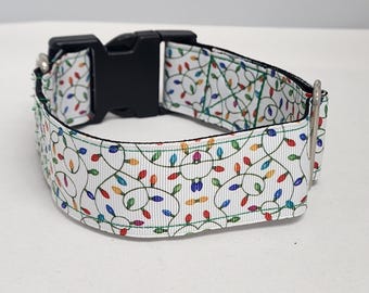 May include: White dog collar with a colorful Christmas lights pattern. The collar has a black plastic buckle.