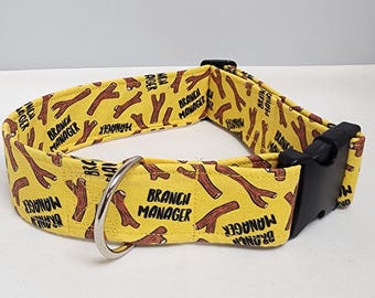May include: Yellow dog collar with a black buckle and a silver ring. The collar has a repeating pattern of brown stick bones and the text "Branch Manager".