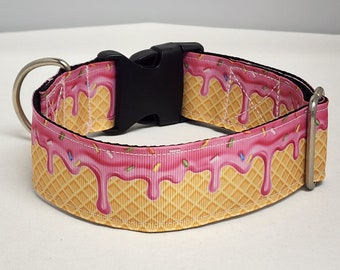 May include: A pink and yellow dog collar with a waffle cone and ice cream design. The collar has a black plastic buckle.