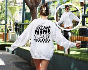 May include: White sweatshirt with black text that reads "Badass Moms Club" with a rock and roll hand gesture graphic.