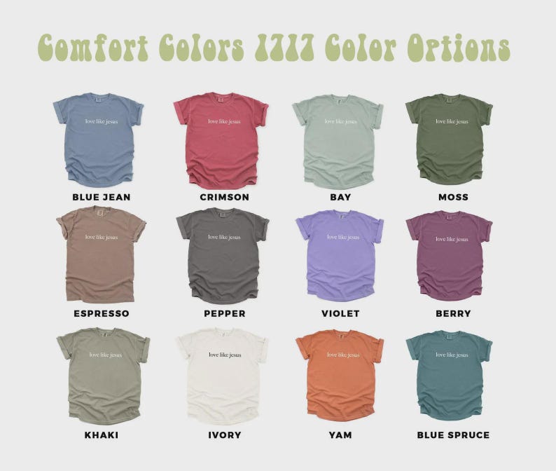 May include: A display of Comfort Colors 1717 t-shirts in various colors, including blue jean, crimson, bay, moss, espresso, pepper, violet, berry, khaki, ivory, yam, and blue spruce. Each shirt has the text "love like Jesus".