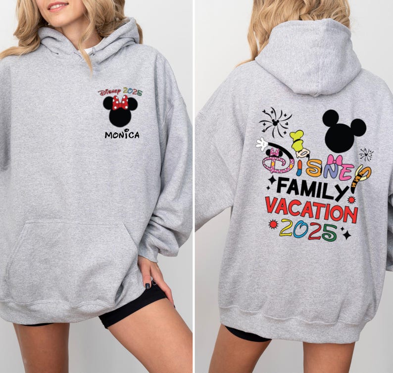 May include: Gray hooded sweatshirt with a Mickey Mouse design on the back. The design includes the text "Disney Family Vacation 2025" and colorful fireworks. The front of the sweatshirt has a smaller Mickey Mouse design with the text "Disney 2025" and "Monica".
