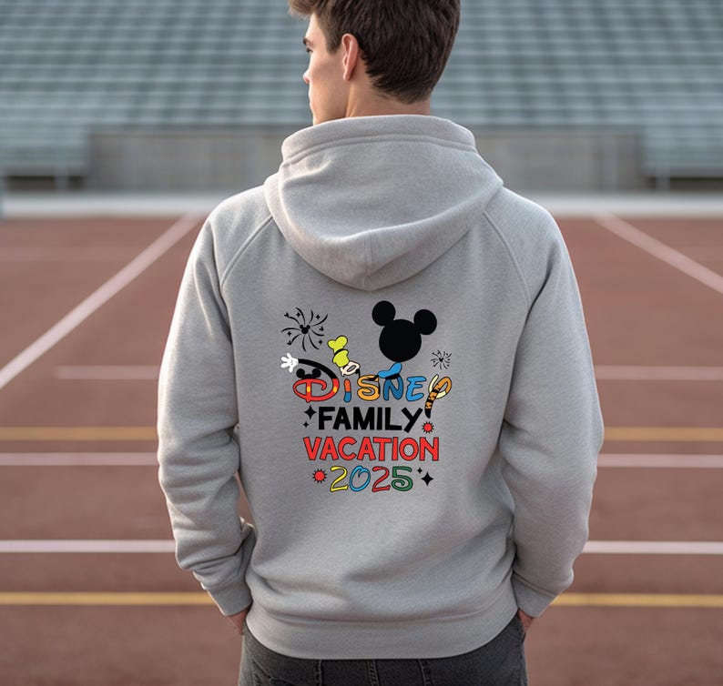 May include: Gray hooded sweatshirt with a colorful Disney Family Vacation 2025 graphic on the back. The graphic includes Mickey Mouse, fireworks, and other Disney characters.
