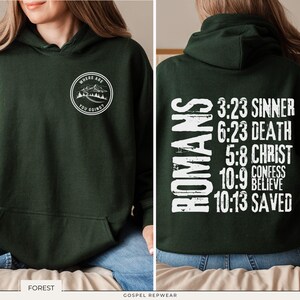 May include: A dark green hooded sweatshirt with a white graphic on the front that says "Where are you going?" and a white graphic on the back that says "Romans 3:23 Sinner 6:23 Death 5:8 Christ 10:9 Confess 10:13 Saved".