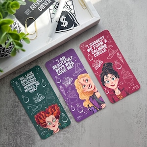 Può includere: Tre carte rettangolari colorate con illustrazioni di personaggi e citazioni di un film. Le carte sono verdi, viola e rosse. La carta verde ha la citazione "Oh, look. Another glorious morning makes me sick!". La carta viola dice "I am beautiful boys will love me!". La carta rossa dice "I suggest we form a calming circle."