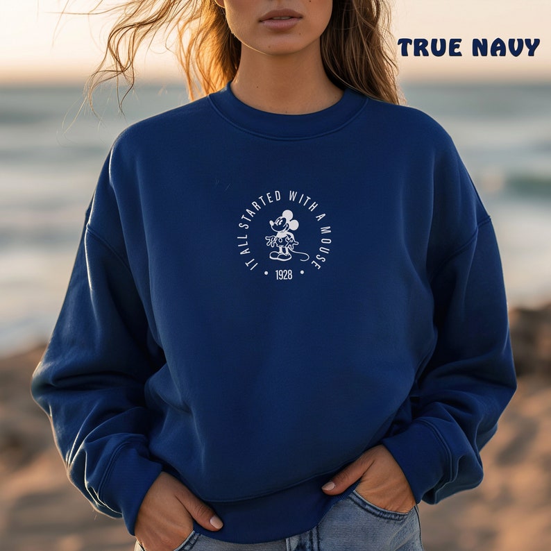 May include: A navy blue sweatshirt with a white graphic of Mickey Mouse and the text "It all started with a mouse. 1928."