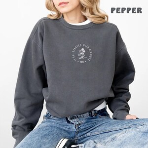 May include: A charcoal grey sweatshirt with a white graphic of Mickey Mouse and the text "It all started with a mouse 1928".