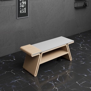 May include: A light wood bench with a white top and a shelf underneath. The bench is sitting on a black and white marble floor.