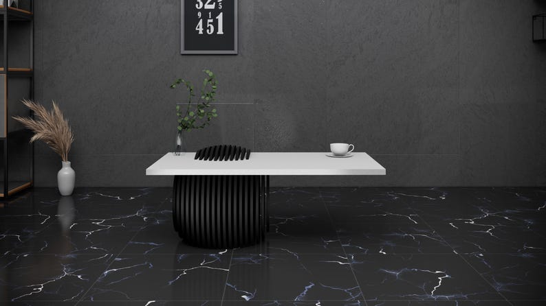 May include: A white table with a black, geometric base sits on a black and white marble floor. A white cup sits on the table.
