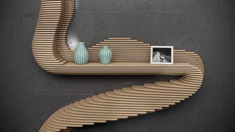 May include: A curved wooden shelf with a unique design, featuring two teal striped vases and a black and white photo frame. The shelf is mounted on a gray wall.