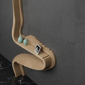 May include: A wooden wall shelf with a unique curved design. The shelf has two small blue vases and a framed photo on it.