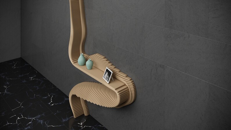 May include: A wooden wall shelf with a unique curved design. The shelf has two small blue vases and a framed photo on it.