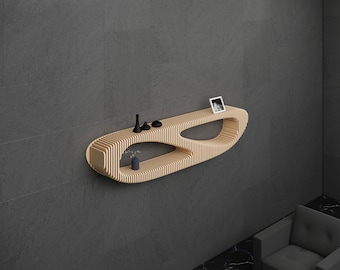 May include: A light wood wall shelf with a unique, organic shape. The shelf has two levels and is mounted on a gray wall. There are small decorative items on the shelf, including a vase with a flower, a small picture frame, and two black figurines.