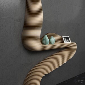 May include: A wooden wall shelf with a unique curved design. The shelf has two small teal vases and a framed black and white photo on it.