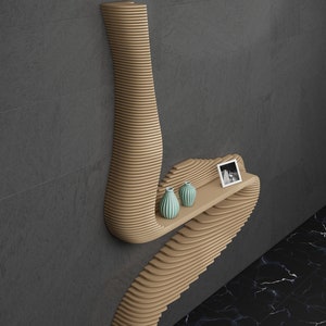 May include: A wooden wall shelf with a unique, wavy design. The shelf has two small, light blue vases and a framed photo on it.