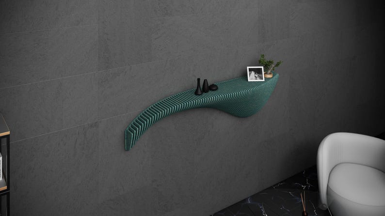 May include: A teal green, curved, wall-mounted shelf with a wood-like texture. The shelf has a small plant and two black decorative items on it.