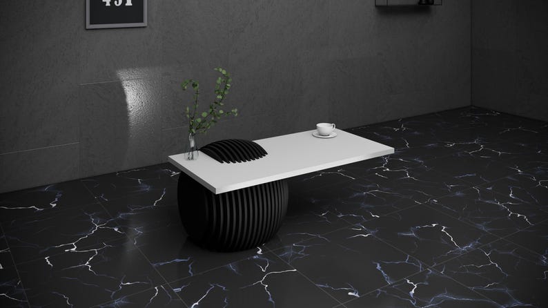 May include: A white table top with a black, round, ribbed base sits on a black and white marble floor. A small white cup and saucer are on the table top.