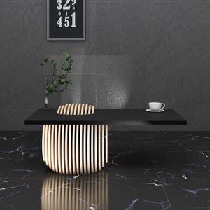 May include: A black table with a wooden slatted chair in front of it. The table has a white cup and saucer on it. The table and chair are in a room with black marble floors and a black wall.