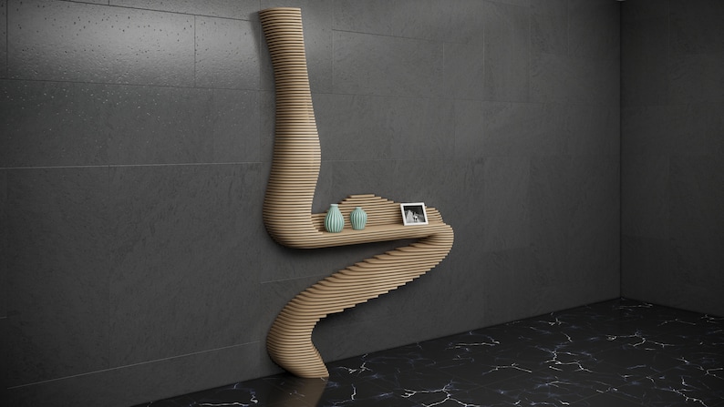 May include: A wooden wall shelf with a unique, curved design. The shelf has three levels and is decorated with two small, light blue vases and a framed photo.