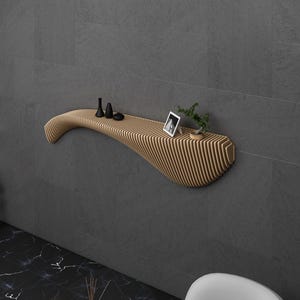 May include: A modern, curved wooden wall shelf with a light wood finish. The shelf is mounted on a gray wall and has a small plant and a framed photo on it.