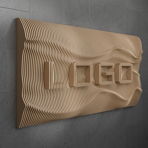 May include: A brown wooden wall art piece with a wavy, layered design. The piece has a series of rectangular cutouts that form the word "IDEO".