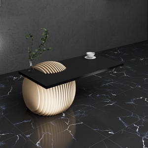 May include: A black and gold modern coffee table with a round base and a rectangular top. The table is made of wood and has a unique design.