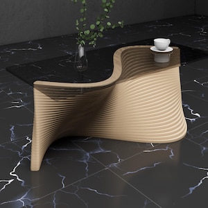 May include: A modern coffee table with a unique, wavy design. The table is made of wood and has a black glass top. The table is sitting on a black and white marble floor.