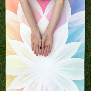 May include: Two images of a person practicing yoga on a custom printed yoga mat. The mat features a colorful mandala design with a white lotus flower in the center. The text "CUSTOM YOGA MATS FOR YOUR BEST PRACTICE" is displayed in pink letters.