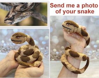Peut inclure: L'image présente un serpent en crochet marron et beige, enroulé et tenu dans les mains. Le serpent a des yeux détaillés et une bouche souriante. L'image comprend également une photo d'un vrai serpent et le texte "Send me a photo of your snake."
