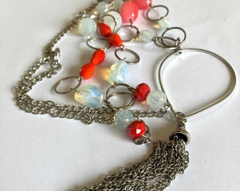 Metal pompom long necklace, coral-colored and transparent faceted glass beads on stainless chain, large rings