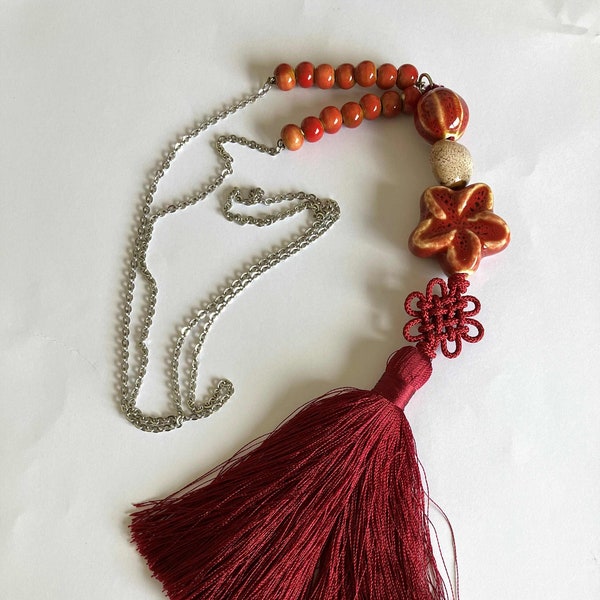 Collier sautoir pompon bordeaux, maedup, perle céramique fleur rouge, coeur beige sur chaîne inoxydable argenté