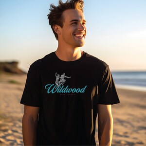 May include: A black t-shirt with a blue and white graphic of two people jumping in the air. The graphic is accompanied by the text "Wildwood, New Jersey".