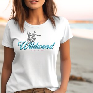 May include: White t-shirt with a blue and pink graphic of two people jumping in the air with the text "Wildwood New Jersey" underneath.