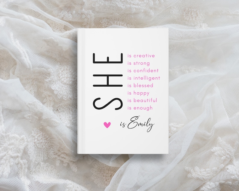 May include: A white card with black text that reads "SHE is creative, is strong, is confident, is intelligent, is blessed, is happy, is beautiful, is enough. ❤ is Emily".