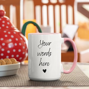 May include: White ceramic mug with a pink rim and handle. The mug has the text "Your words here" written in black cursive with a small heart below the text.